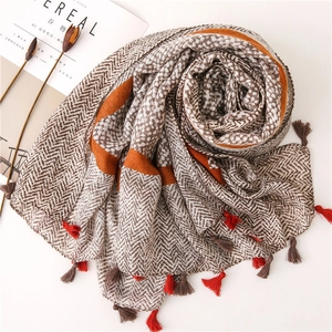 Close-up of leopard print cotton linen scarf with herringbone pattern and fringe detail