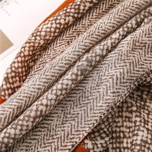 Detailed close-up of herringbone and leopard print cotton linen scarf with soft fringe