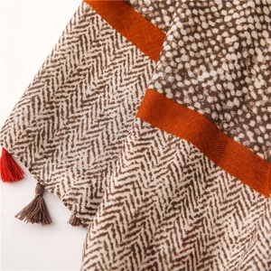Close-up of cotton linen scarf featuring herringbone, snake print patterns and tassels