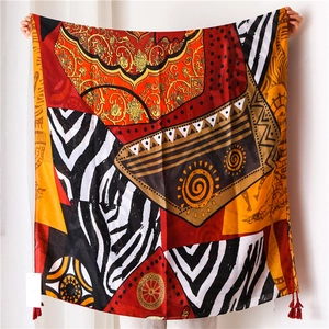 Close-up of ethnic totem scarf featuring geometric patterns and red fringe tassels
