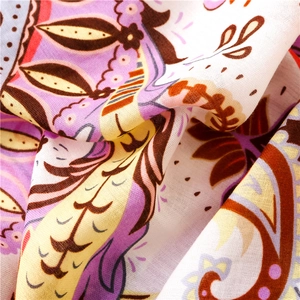 Détail macro d'une écharpe légère en coton et lin aux motifs floraux paisley violets