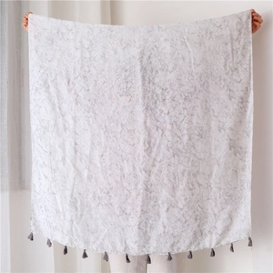 Detail of grey marble pattern linen scarf featuring delicate small tassels on the edge
