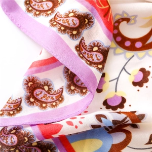 Détail macro du motif paisley floral d'été et couture fine sur le châle de plage violet