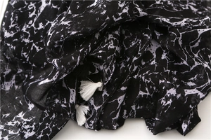 Detailed view of black and white marble print cotton linen scarf with elegant fringe trim