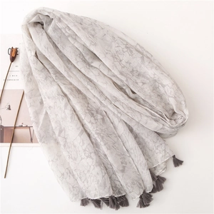 Detail of grey marble pattern scarf with soft tassels on minimalist white background