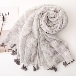 Detail of a gray marble pattern cotton linen scarf with dark gray tassel accents