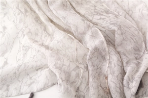 Close-up of lightweight linen cotton scarf showing grey marble pattern and fringe detail