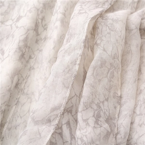 Detailed macro view of the marble print fabric showing fine stitching on the linen scarf