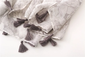 Detail of marble pattern cotton scarf showing soft texture and grey tassel fringe edges