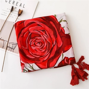 Detail of red rose print scarf with fringe tassels on minimalist white background