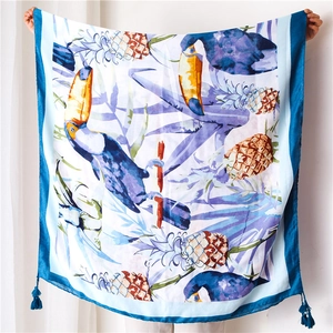 Détail de l'écharpe avec imprimé toucan et ananas et pompons bleu marine