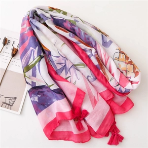 Détail d'une écharpe en coton et lin avec imprimé tropical et pompons fuchsia