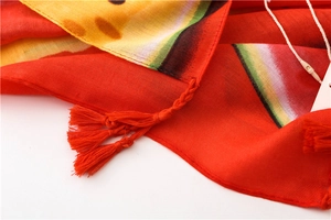 Détail d'une écharpe en coton rouge avec motif pastèque et glands tissés à la main