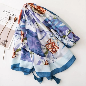Détail d'écharpe en coton et lin avec imprimé ananas tropical et pompons bleu foncé