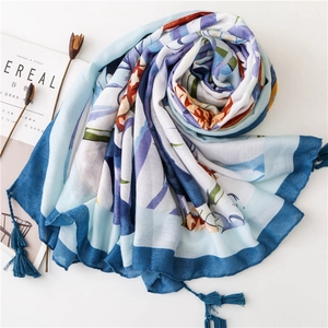 Détail d'une écharpe en coton-lin doux avec motif tropical, tons bleus et franges