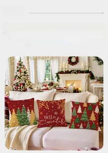 Detail of red Christmas pillow covers with festive tree prints on a cozy sofa setting