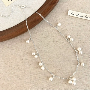 Detailed view of white pearl necklace with silver chain and adjustable lobster clasp