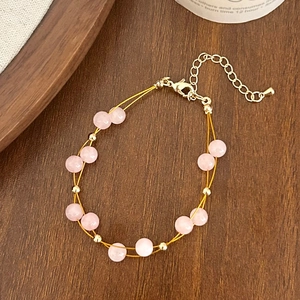 Detail of pink double-layer beaded bracelet with gold accents and adjustable lobster clasp