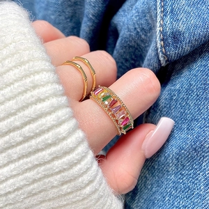 Rainbow zircon open ring in gold finish worn with stackable bamboo textured rings