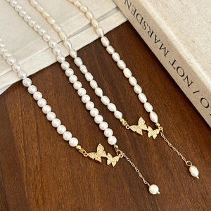 Elegante Perlenkette mit goldenem Schmetterlingsanhänger und glitzernden Zirkoniasteinen