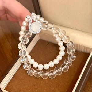 Macro detail of elegant double-layered pearl and crystal bead bracelet on velvet box