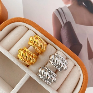 Detailed view of twisted rope hoop earrings in gold and silver finish on display
