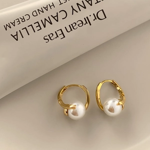 Boucles d'oreilles dorées élégantes avec perle blanche centrale dans un style vintage épuré