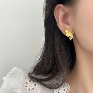 Golden butterfly stud earrings with water drop zircon shown on a female model