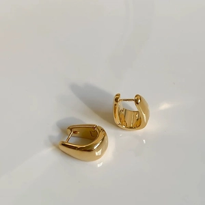 Minimalist gold U-shaped hoop earrings with a high-polished metallic mirror finish