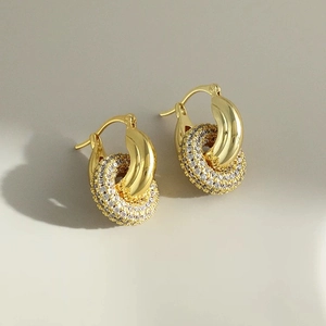 Detailed view of intertwined gold hoop earrings with sparkling cubic zirconia pavé setting