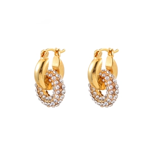 Close-up of golden geometric earrings with pave-set sparkling cubic zirconia rings