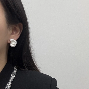 Élégantes boucles d'oreilles coquillage en argent avec perle blanche sur l'oreille