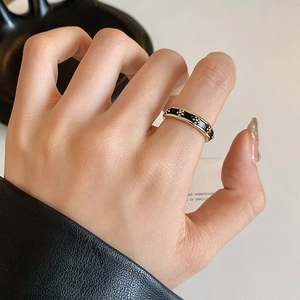 French retro gold ring with black enamel and white flowers on a hand with black leather