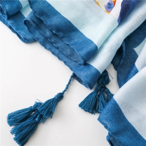 Détail d'une écharpe en coton à rayures bleues montrant la texture et les franges
