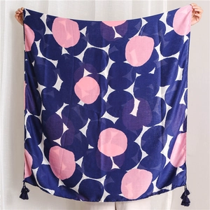 Close-up of navy blue linen-feel shawl featuring large pink polka dots and fringe details