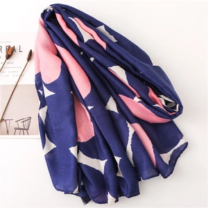 Long navy cotton linen scarf with pink polka dots and fringe, styled with magazine