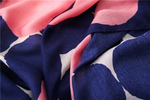Detailed macro view showing the soft cotton linen texture and navy floral polka dot pattern