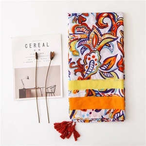 Ethnic floral print shawl with red tassels on white background with cereal magazine