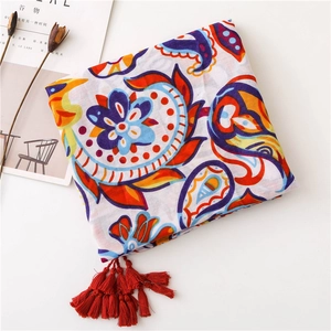 Detailed view of ethnic paisley floral patterns and red tassels on lightweight scarf