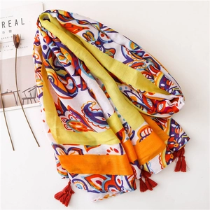Ethnic bohemian print scarf with tassels on white surface with cereal magazine