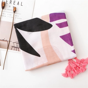 Detail of bohemian cotton linen scarf with abstract print and pink fringe tassels