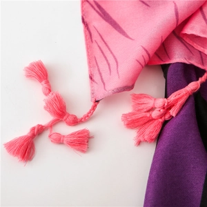 Macro detail of pink bohemian scarf featuring woven tassels and striped linen texture