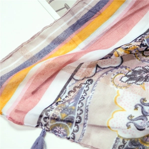 Detail of bohemian cotton scarf with gold foil printing, colorful stripes and fringe