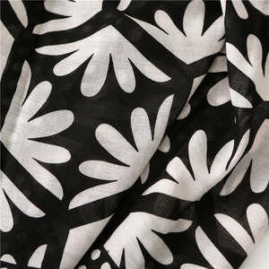 Detail of lightweight black fabric with white abstract floral prints and soft draping