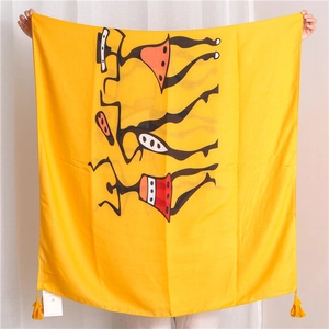 Detail of yellow cotton linen scarf featuring tribal silhouettes and yellow tassels