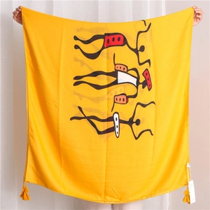 Detail of yellow cotton linen scarf with black tribal portrait print and fringe tassels