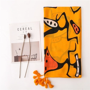 Yellow cotton linen scarf with abstract patterns and decorative orange tassels