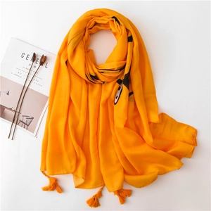 Bright yellow cotton linen scarf with black line art figures and fringe edges