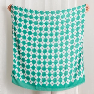 Detail of green floral print shawl showing lightweight fabric and fringe edges