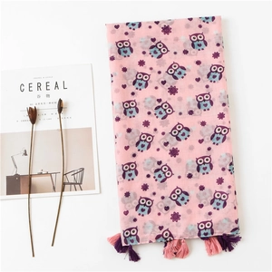 Detailed view of owl print pattern and tassels on lightweight pink cotton linen scarf